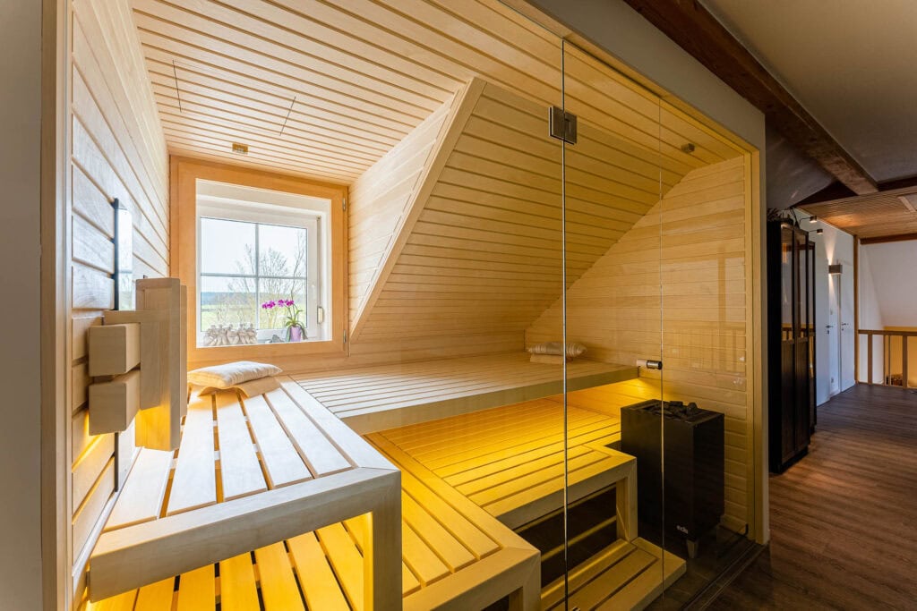 Sauna unter der Dachschräge mit Gaubenfenster, Ofen an der Glasfront