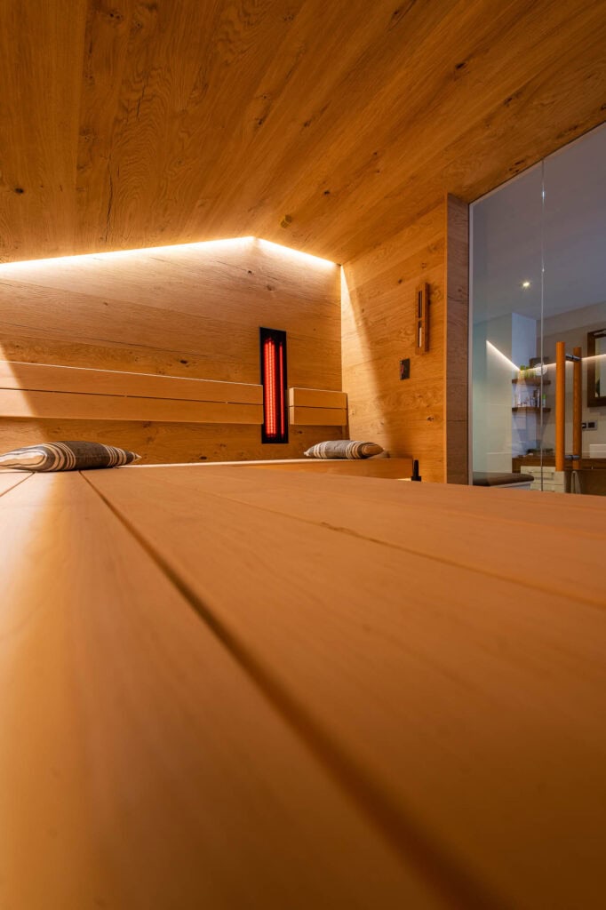 Blick über die Liegefläche zur Glasfront, dahinter das Badezimmer